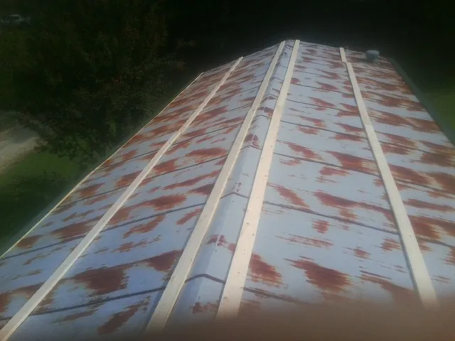 Rusted metal roof panels with new wood purlins before replacement — Storm Damage Roof Repair in Westford by Roofing Brothers