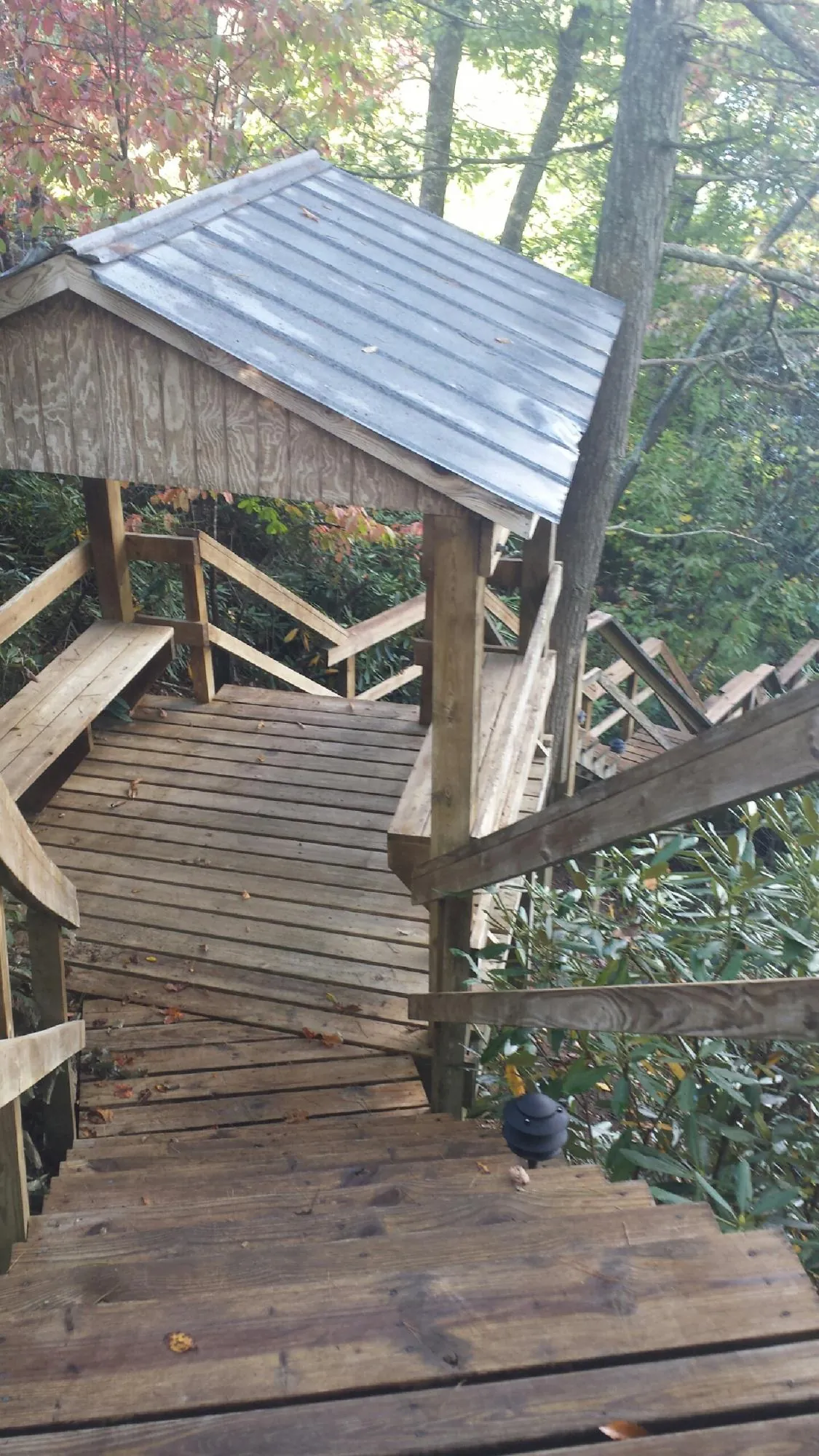 Metal roofed shelter over wooden steps on a wooded walkway — Skylight Repair & Installation work by our crew in Westford