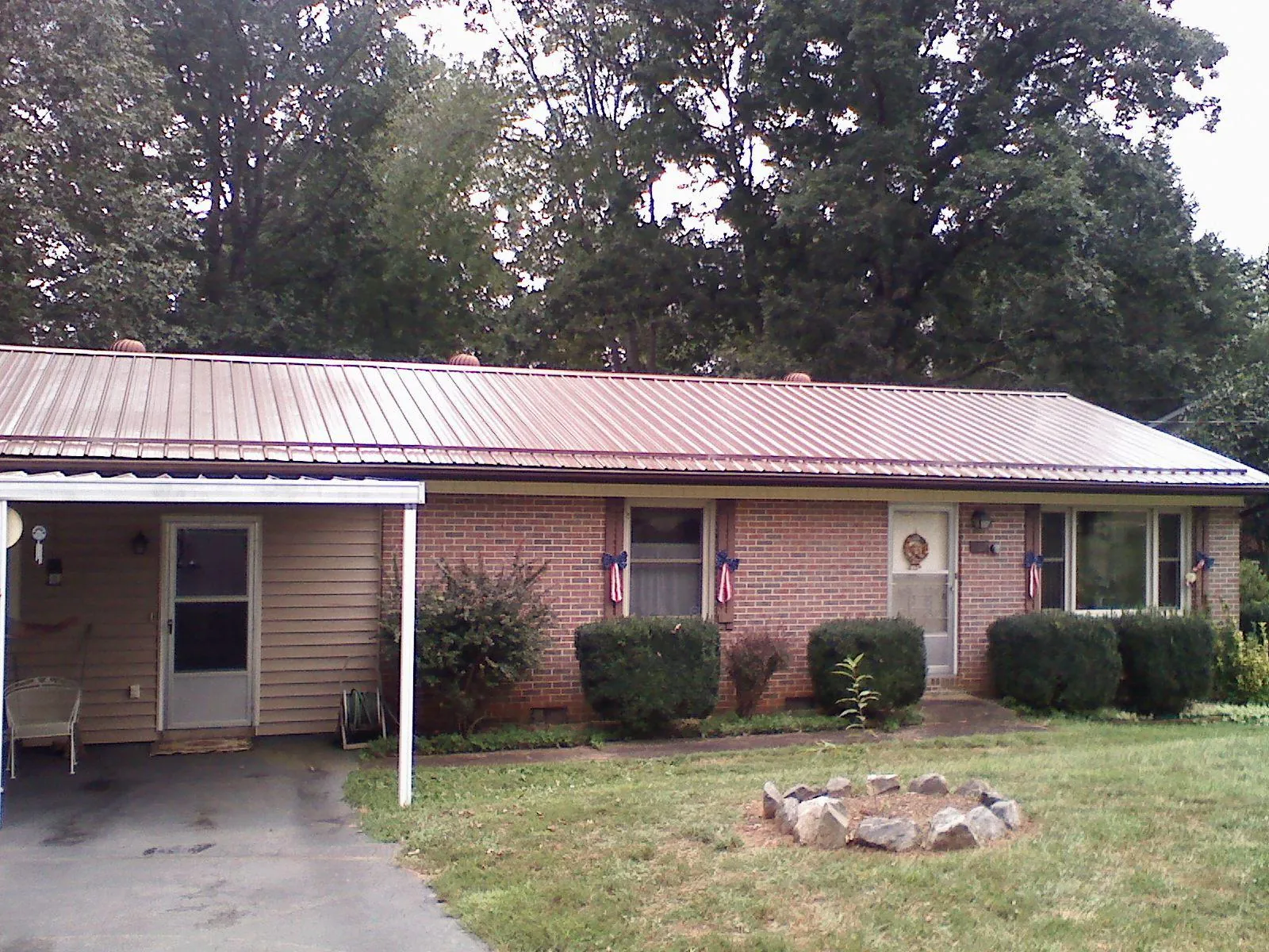 Bronze metal roof and carport on a brick ranch home — Roof Repair work by our crew in Westford